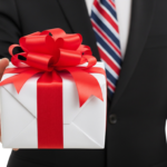 Businessman Hand Holding Out Red Ribbon Gift Box Present